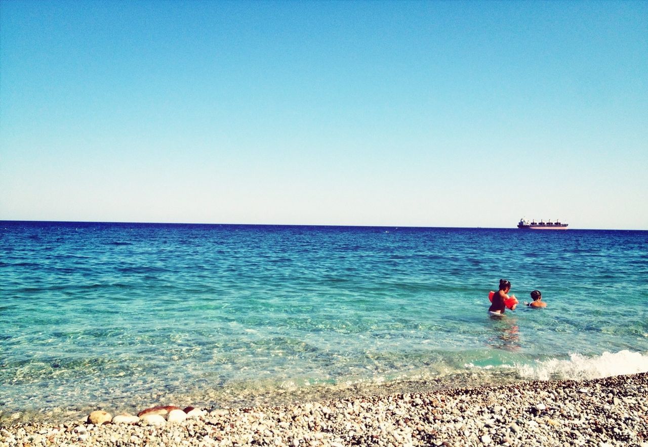 sea, water, horizon over water, clear sky, beach, copy space, leisure activity, shore, lifestyles, tranquil scene, beauty in nature, scenics, tranquility, blue, nature, vacations, men, rear view