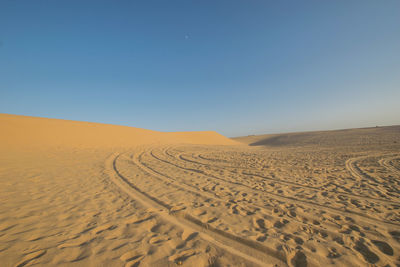 Scenic view of desert against clear blue sky