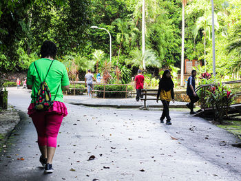 Rear view of people walking on footpath