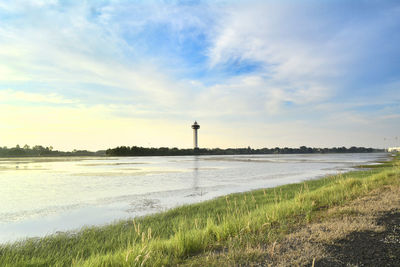 Lighthouse by sea against sky