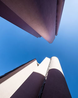 Low angle view of modern building against clear blue sky