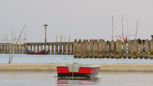 Sailboats moored in sea against clear sky