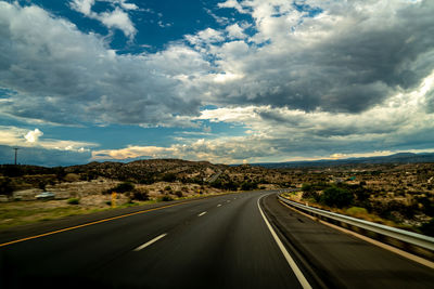 Road passing through landscape against sky