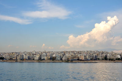 View of buildings in city against cloudy sky