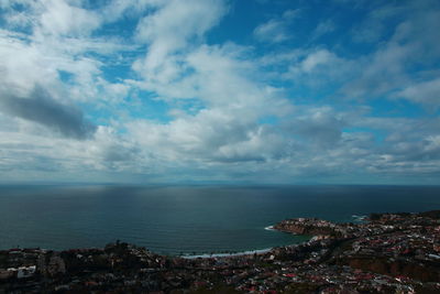 Aerial view of townscape by sea against sky