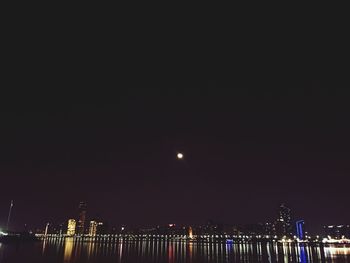 Illuminated city against sky at night