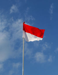 Low angle view of flag against blue sky