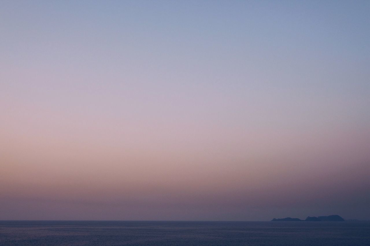 SCENIC VIEW OF SEA AGAINST CLEAR SKY AT DUSK