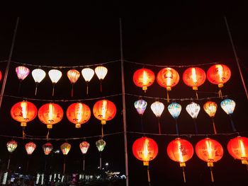 Low angle view of illuminated lanterns hanging at night