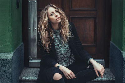 Portrait of young woman sitting outdoors