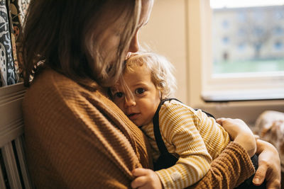 Mother hugging son at home