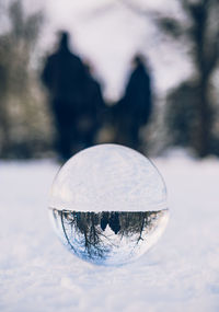 Close-up of crystal ball on snowy field