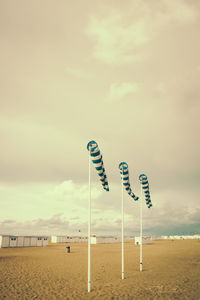 Information sign board on beach against sky