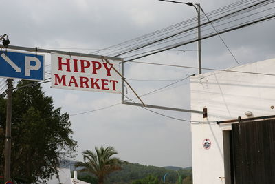 Low angle view of information sign against sky