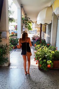 Full length of woman standing by flowering plants