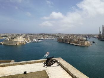 High angle view of cityscape by sea against sky