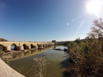 Bridge over river against clear blue sky