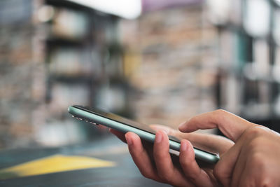 Midsection of person using mobile phone outdoors
