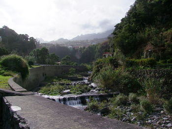 Scenic view of river by mountains against sky