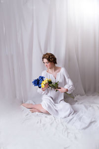 Ukrainian girl with blue yellow flowers in white