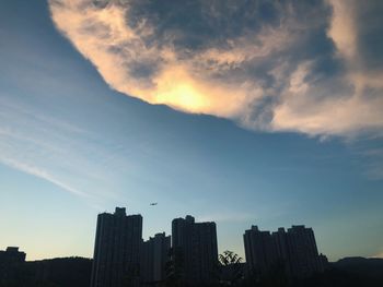 Silhouette of buildings against cloudy sky