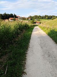 Road amidst field against sky