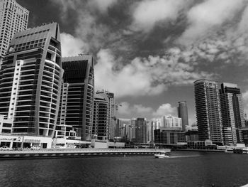 Buildings in city against cloudy sky