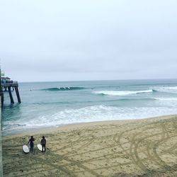 People standing on beach against sky