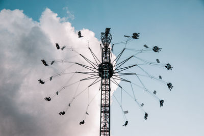 Low angle view of chain swing ride against sky