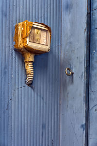 Close-up of electric equipment mounted on purple wall