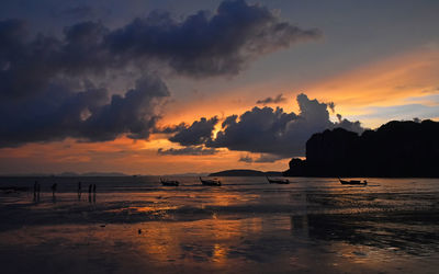 Silhouette boats in sea against sky during sunset