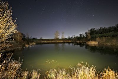 Scenic view of lake against sky at night