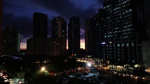 Illuminated buildings in city against sky at night