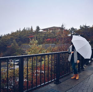 Rear view of woman walking on mountain against clear sky