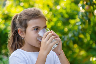 Girl drinking water outdoors