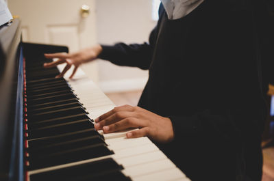 Midsection of man playing piano