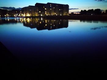 Reflection of buildings in lake at night
