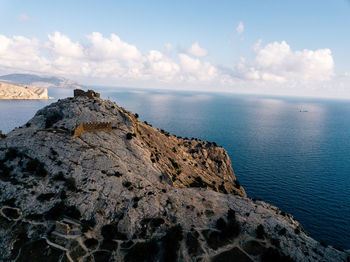 Rock formations by sea against sky