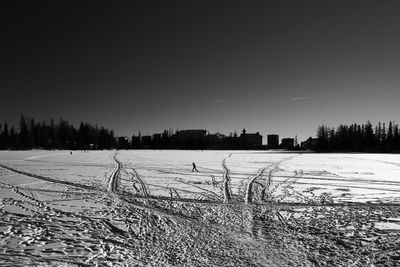 Scenic view of snowy field against clear sky during winter