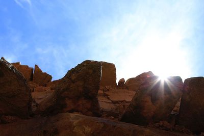 Rock formations on landscape against cloudy sky