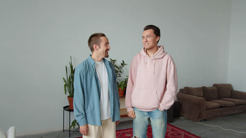 Portrait of smiling couple standing against wall