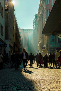 People walking on street amidst buildings in city