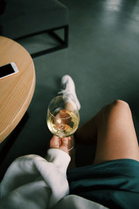 Midsection of man drinking glass on table