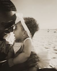 Rear view of mother and daughter at beach