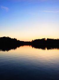 Reflection of clouds in calm lake at sunset