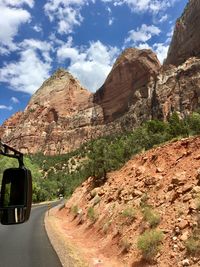 Road by rock formation against sky