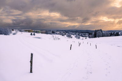 Scenic view of snow covered landscape against sky during sunset