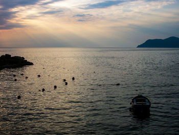 Boats in sea at sunset