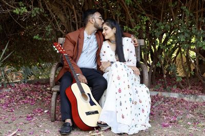 Rear view of couple sitting outdoors