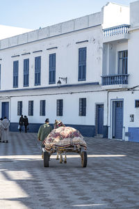 People on street against buildings in city